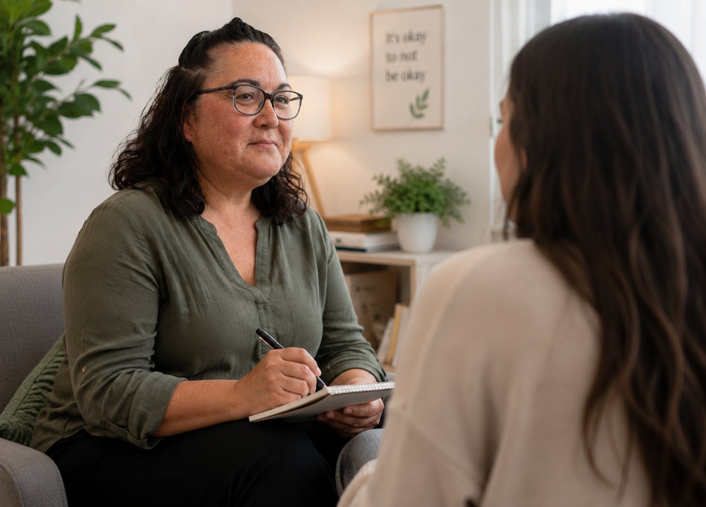 Vanessa Sinclair sitting with a participant in a lounge room, taking notes as they talk